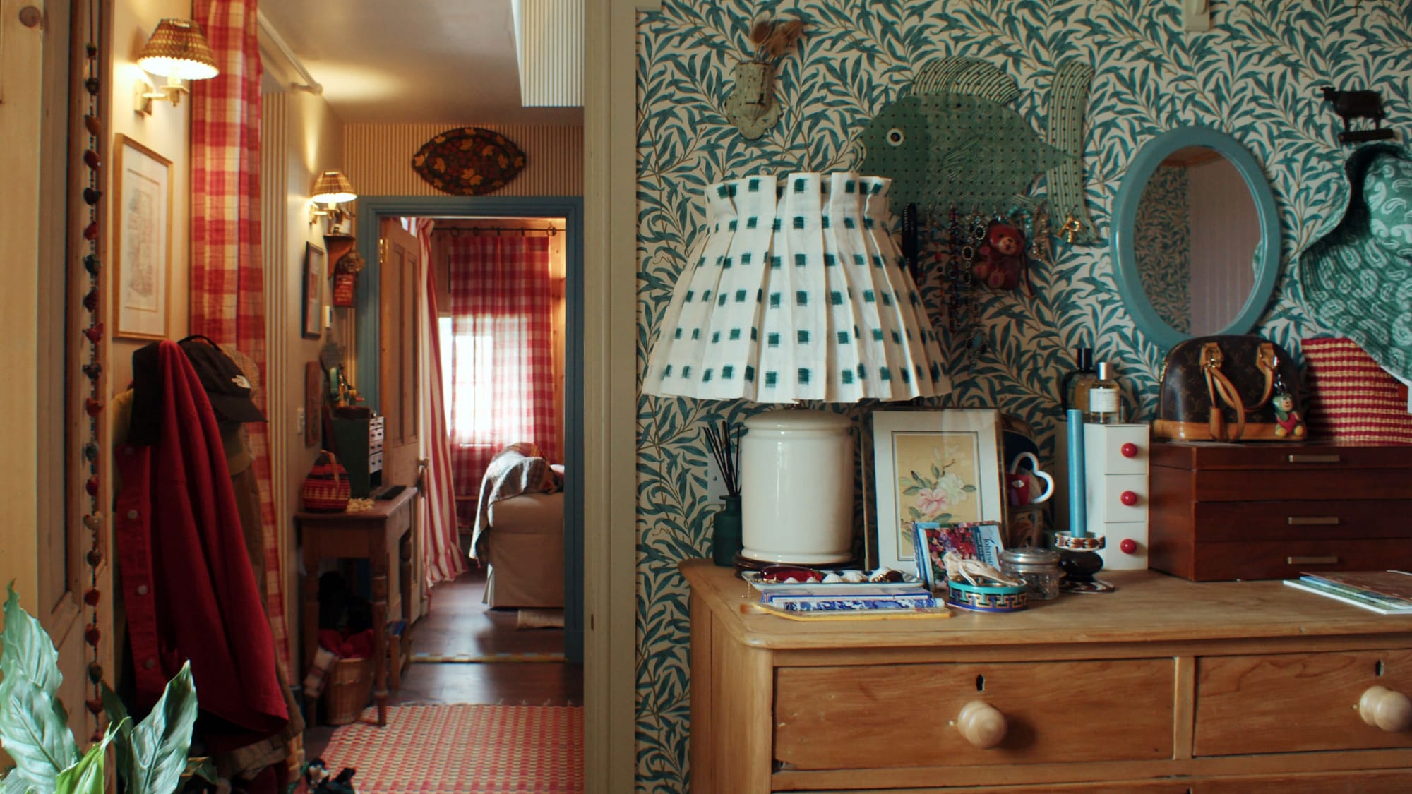 Cosy hallway with patterned wallpaper, wooden chest of drawers, table lamp and checked curtains